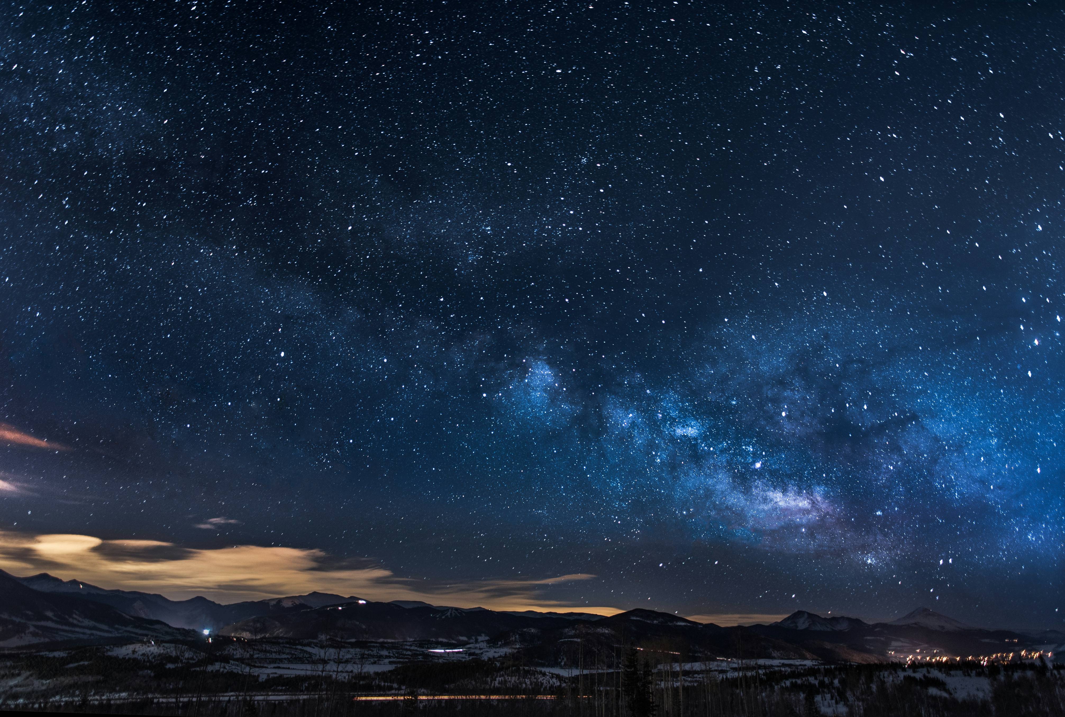 mountains with trees under white star at night