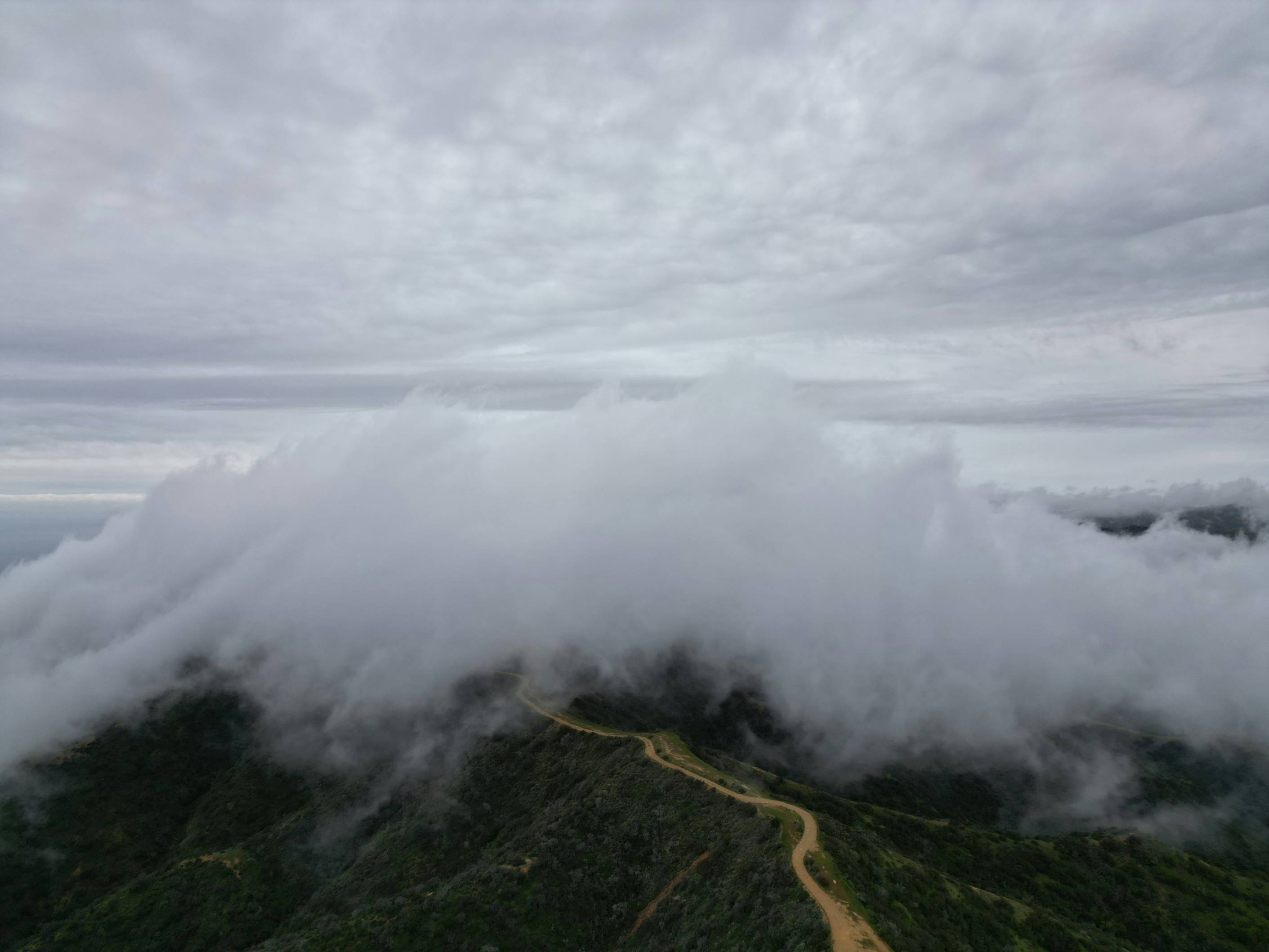 An aerial view of a mountain covered in clouds