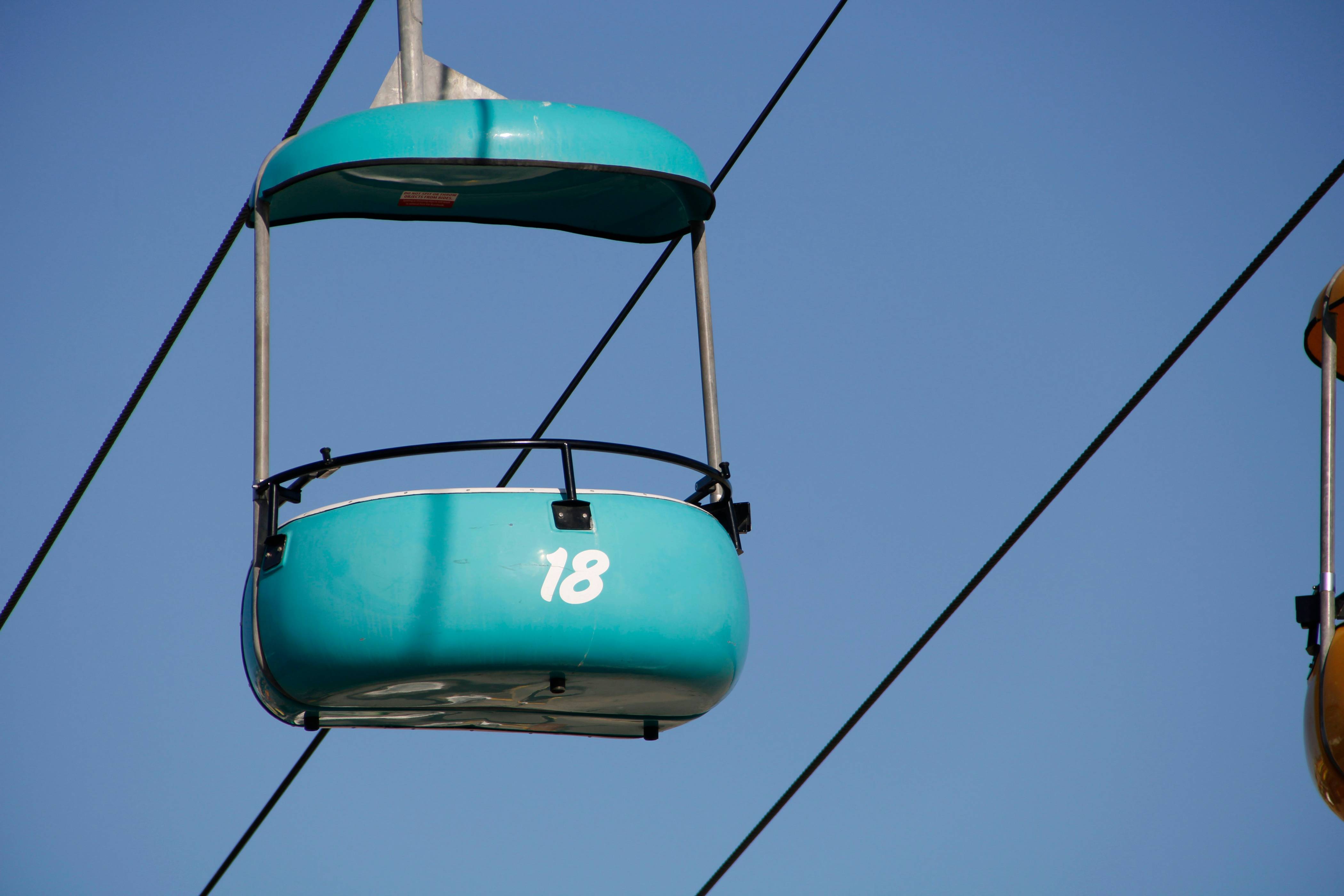 blue and white cable car under blue sky during daytime